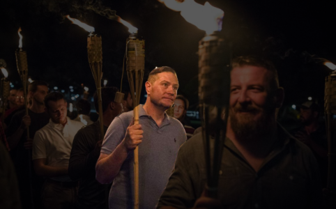 Eric Atwood holding a tiki torch with other white nationalists